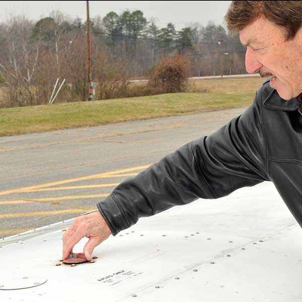 man checking aircraft fuel cap